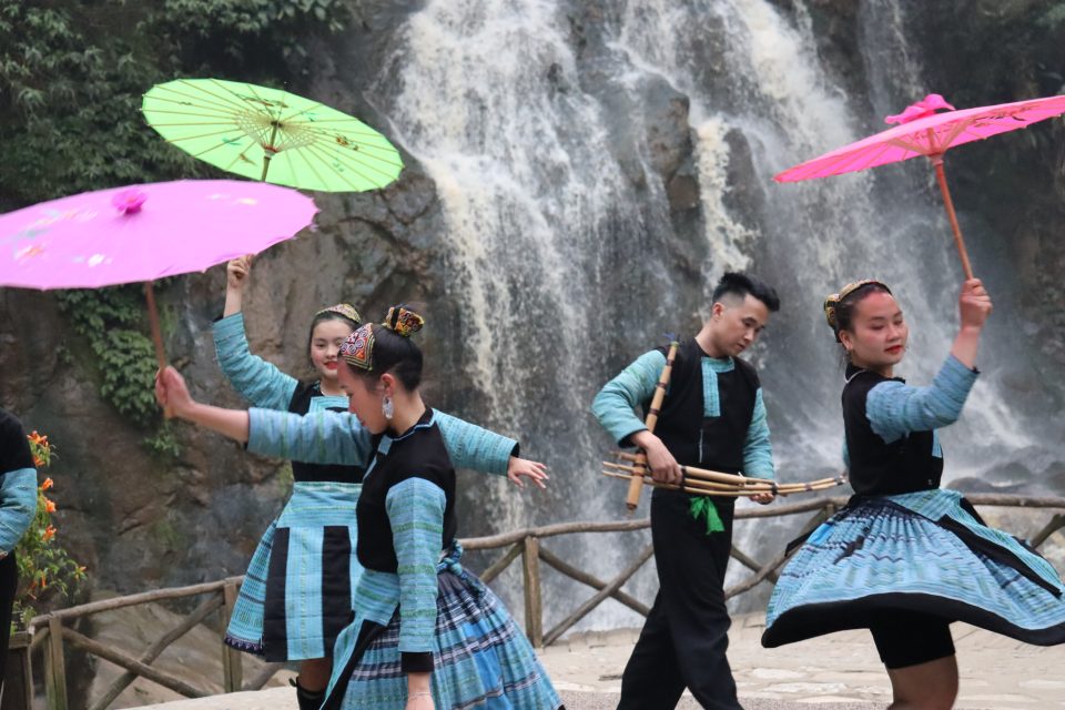 Ragazzi vietnamiti che ballano, sotto ad una cascata nella città di Sapa, al confine con la Cina. 