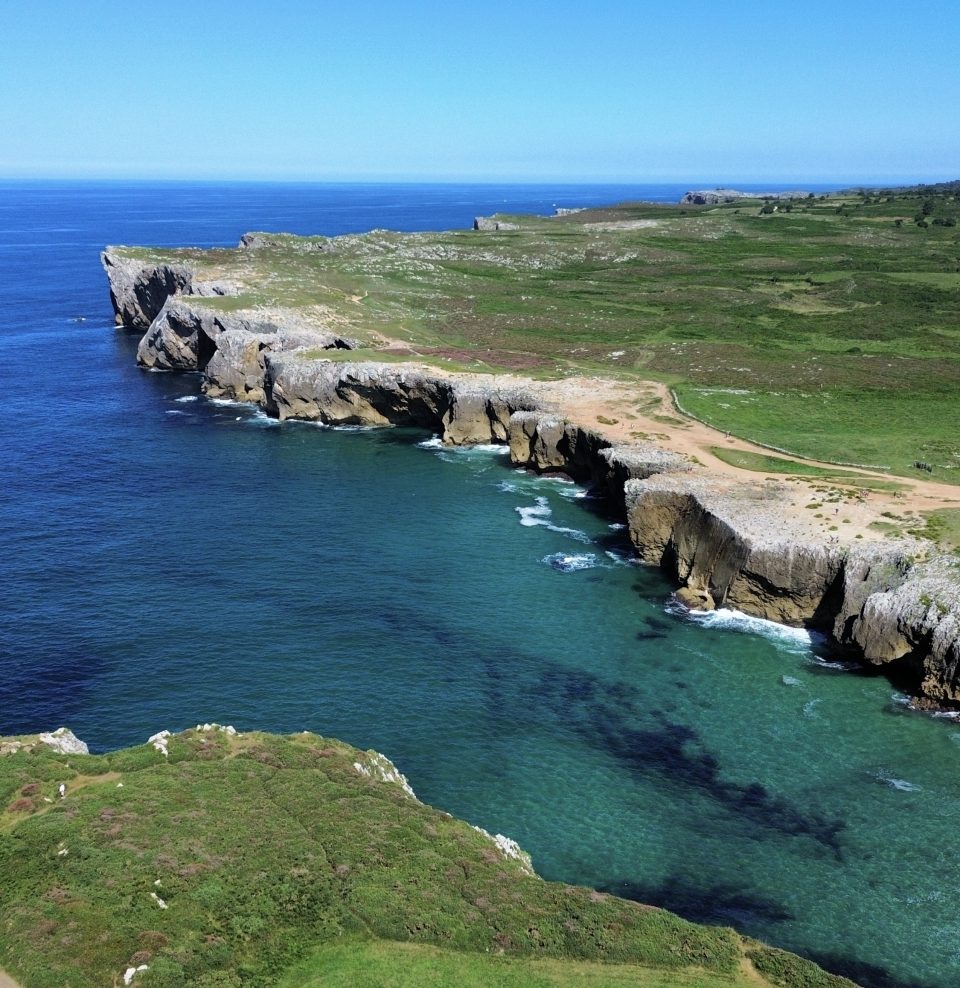 "una meravigliosa costa rocciosa a picco sull'oceano dai colori azzurri e blu"